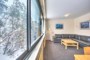 a living room with a couch and a large window at Snow Ski Apartments 09 in Falls Creek