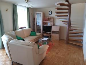 ein Wohnzimmer mit einem Sofa und einer Wendeltreppe in der Unterkunft Getaway "At the three lights" in Sevnica