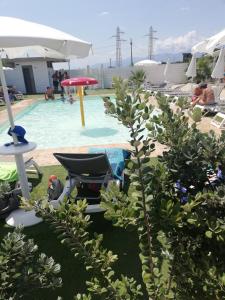 a swimming pool with a chair and an umbrella at All'Ombra Del Noce B&B in Catona