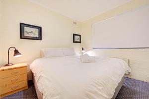 a bedroom with a large white bed and a window at Snow Ski Apartments 31 in Falls Creek