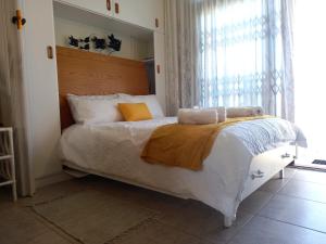 a bedroom with a white bed with a large window at Ocean Breeze 9 in Amanzimtoti