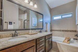 a bathroom with a sink and a tub and a mirror at Casa De Arbol in El Paso +33 photos