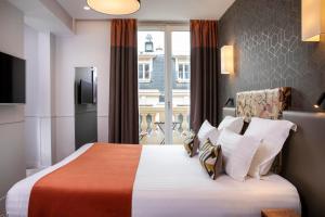 pokój hotelowy z łóżkiem i oknem w obiekcie Daunou Opéra w Paryżu
