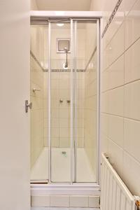 y baño con ducha y puerta de cristal. en Snow Ski Apartments 28, en Falls Creek