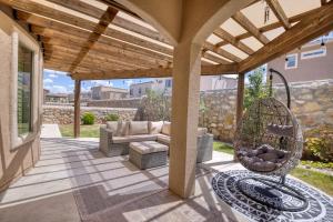 a patio with a couch and a chair under a pergola at Casa De Arbol in El Paso