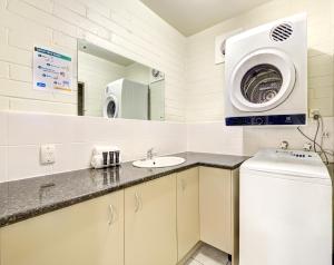 a laundry room with a sink and a washing machine at Snow Ski Apartments 27 in Falls Creek