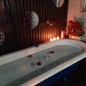 a bath tub filled with blood with candles and flowers at rooms with a view in Haywards