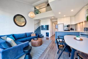 a living room with a blue couch and a table at Snow Ski Apartments Penthouse 33 in Falls Creek +11 photos