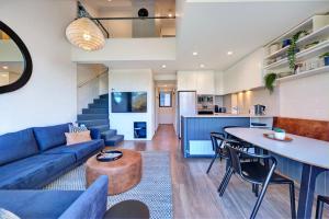 a living room with a blue couch and a table at Snow Ski Apartments Penthouse 33 in Falls Creek