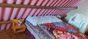 1 dormitorio pequeño con 1 cama y 1 silla en Chalé Barco da areia, en São Mateus