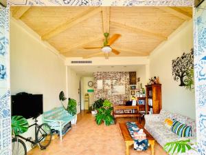 SpoonDrift Hostal Kenting في نانوان: غرفة معيشة مع أريكة ومروحة سقف