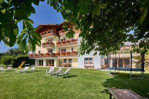 a large house with chairs in the yard at Residence Schiestlhof in Natz-Schabs