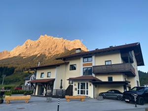 ein großes Gebäude mit einem Berg im Hintergrund in der Unterkunft Tiroler Alpblick Appartements in Ehrwald