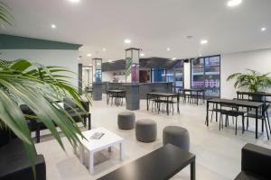 a restaurant with tables and chairs and a kitchen at Hotel Base - Adults Only in San Antonio