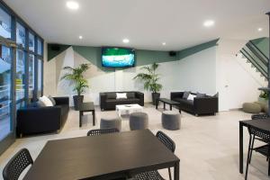 a lobby with couches and tables and a tv at Hotel Base - Adults Only in San Antonio