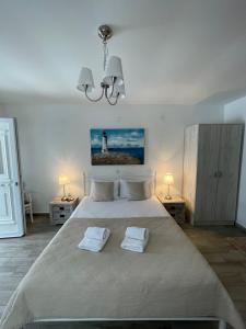 a bedroom with a large bed with two towels on it at Alkyonari By Maria in Ammouliani