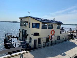 a house boat on a dock in the water at Island-dreams Hausboote Groth & Rhin in Schleswig