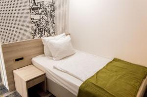 a small bedroom with a bed and a table at Hotel Cosmopolit in Sarajevo