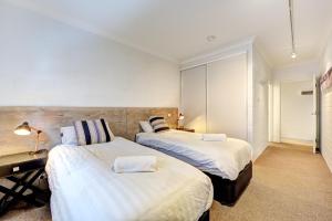 a bedroom with two beds and a desk in it at Snow Ski Apartments 39 in Falls Creek