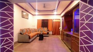 uma sala de estar com um sofá e uma televisão de ecrã plano em Kushi HomeStay Guest House em Visakhapatnam