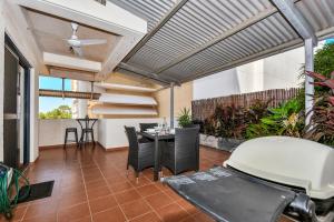 un patio con mesa, sillas y techo en Central Studio, Darwin CBD Northern Territory en Darwin