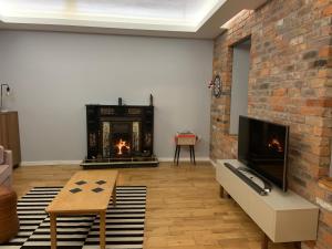 a living room with a brick wall and a fireplace at Fortwilliam Farm T12DNN2 in Cork