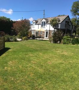 a house with a lawn in front of it at The Barn at Well Cottage in Bude