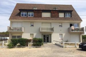 una casa bianca con il tetto marrone di Studio, proche du Touquet, tout équipé à 100m de la plage a Stella-Plage