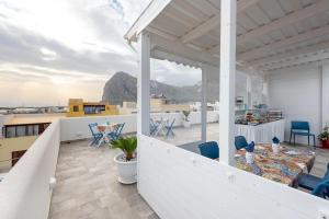 un balcone di una casa con tavolo e sedie di Scrusciu du mari a San Vito lo Capo