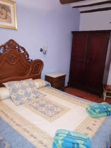 uma cama com uma cabeceira em madeira num quarto em Casa Cartujet em Calaceite