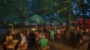 un gruppo di persone seduti ai tavoli in un ristorante all'aperto di Camping Sokol Praha a Praga Altre 83 foto