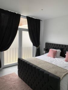 een slaapkamer met een groot bed met roze kussens bij Appartement op Italiëlei in Antwerpen