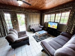 a living room with couches and a flat screen tv at Masasana’s Rest in Hazyview
