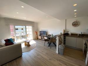 Una sala de estar con un sofá y una cocina con una mesa. en Perla del Mar, en Platja d'Aro