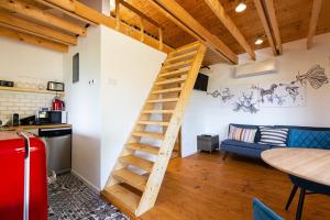 a wooden staircase in a kitchen and a living room at Napkelet Vendégház in Nagymaros