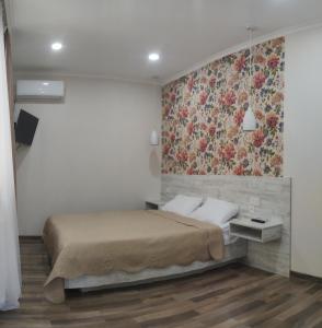 ein Schlafzimmer mit einem Bett mit Blumenbild an der Wand in der Unterkunft Akaki's Guesthouse in Bordschomi