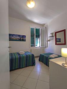 a room with two beds and a window at Blackstone Apartment in Varazze