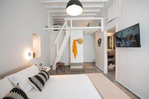 salon z białą kanapą i schodami w obiekcie Avli Suites w mieście Mykonos