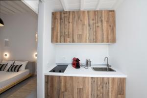 a kitchen with wooden cabinets and a sink at Avli Suites in Mýkonos City