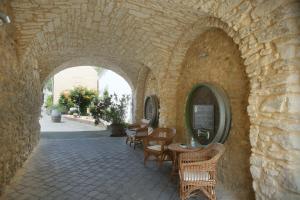 a stone archway with a table and chairs in a building at Winzerzimmer - Weingut Tinhof in Eisenstadt