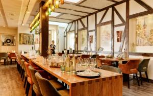 um restaurante com uma mesa longa e cadeiras em Hotel Zeltinger-Hof - Gasthaus des Rieslings em Zeltingen-Rachtig