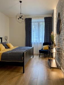 a bedroom with a bed and a chair and a brick wall at 29 Gdynia Centrum - Apartament Mieszkanie dla 4 os in Gdynia