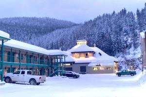 a snow covered building with a truck parked in a parking lot at Super 8 by Wyndham Sicamous in Sicamous