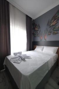 1 dormitorio con 1 cama blanca y ventana en Victorious Hotel en Estambul