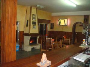 a bar with a fireplace in a restaurant at Hostal Poncebos in Poncebos