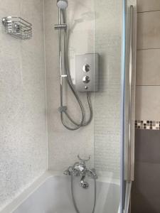 een douche in een badkamer met een bad bij Westlea Bed and Breakfast in Thurso