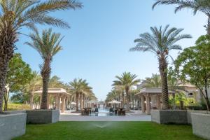 a park with palm trees and a fountain at Apartment in Dubai