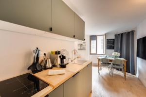 a kitchen with a counter and a table with chairs at L'Atelier Filaterie - Apartment for 2 people in Annecy