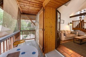 Zimmer mit einem Balkon mit einem Tisch und einem Sofa in der Unterkunft Le Triplex Carnot - Apartment with air conditioning for 5 people in Annecy