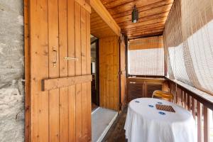 Zimmer mit einem Tisch auf einem Balkon mit Tür in der Unterkunft Le Triplex Carnot - Apartment with air conditioning for 5 people in Annecy